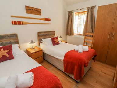 A bedroom with two beds and decorative paddles at Hideaway Cottage No 1 Seahouses