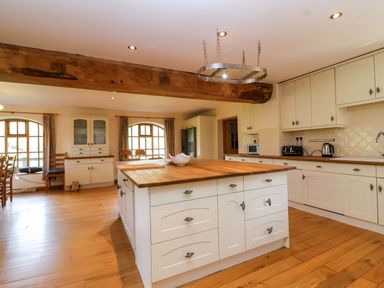 A kitchen with wooden elements and appliances at Millbarn in Crowcombe