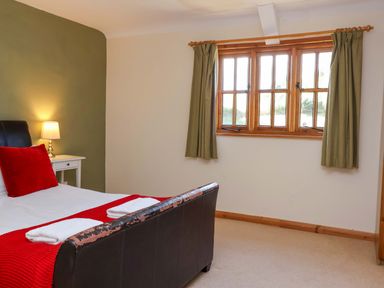 A bedroom with a bed and lamp at Millbarn in Crowcombe