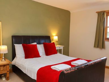 A bedroom with a bed and bedside lamps at Millbarn in Crowcombe