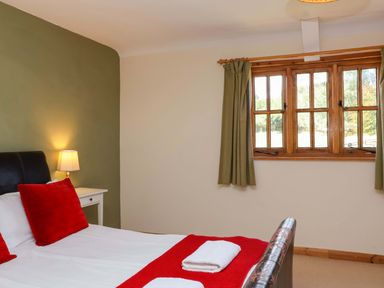 A bedroom with a bed and window at Millbarn in Crowcombe