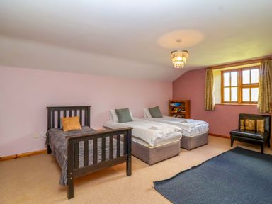 A bedroom with two single beds and a bookshelf at Millbarn in Crowcombe