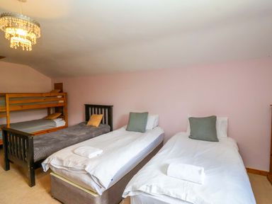 A bedroom with two single beds and a bunk bed at Millbarn in Crowcombe