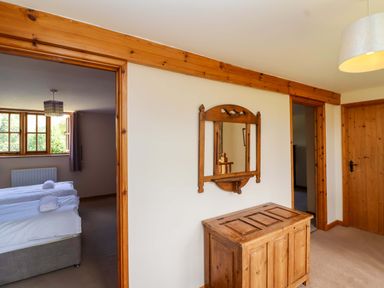 A bedroom with a twin bed and wooden furniture at Millbarn, Crowcombe