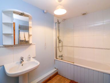 A bathroom with sink and bath at Millbarn in Crowcombe