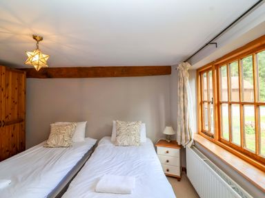 A bedroom with twin beds and a window at Millbarn in Crowcombe