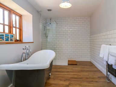 A bathroom featuring a bathtub and shower at Millbarn in Crowcombe