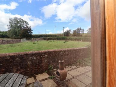 A garden with a chimenea and stone pathway at Millbarn Crowcombe
