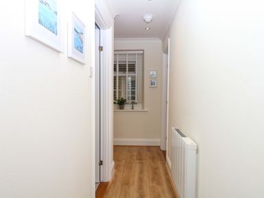 A hallway with a window and pictures on the wall at 2 Sheplegh Court Blackawton near Dartmouth