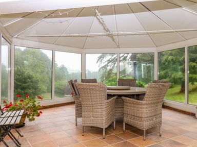 A conservatory with a table and chairs at 2 Sheplegh Court in Blackawton near Dartmouth