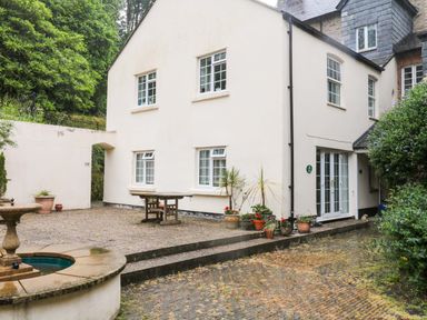 An outdoor area with a table and plants at 2 Sheplegh Court Blackawton near Dartmouth