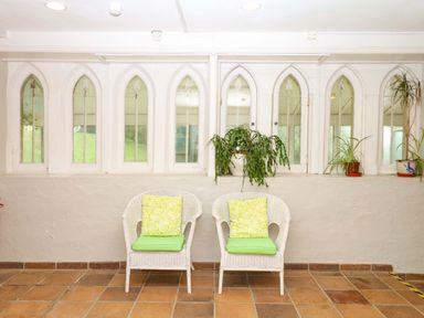 A conservatory with two chairs and plants at 2 Sheplegh Court Blackawton near Dartmouth