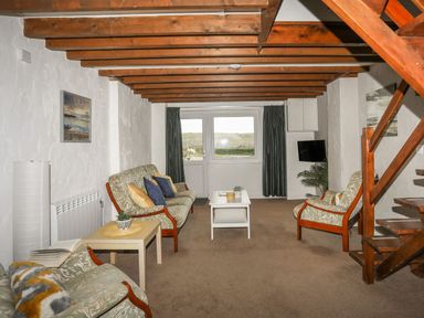 A living room with sofas, a coffee table, and a television at Fadrun - 3 Ty'n Don