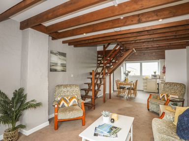 A living room with a staircase and dining area in Fadrun - 3 Ty'n Don