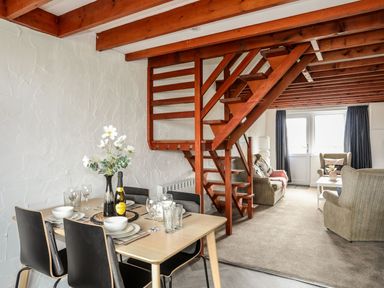 A dining room with a table and chairs at Penrhyn - 4 Ty'n Don
