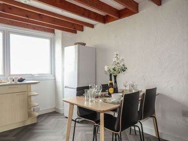 A kitchen with a dining table and chairs at Penrhyn - 4 Ty'n Don