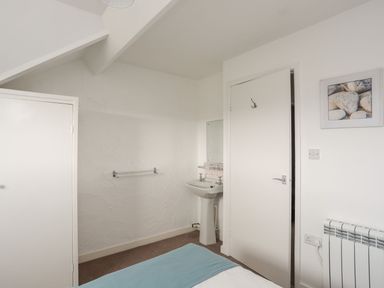 A bathroom with a sink and a mirror at Penrhyn - 4 Ty'n Don