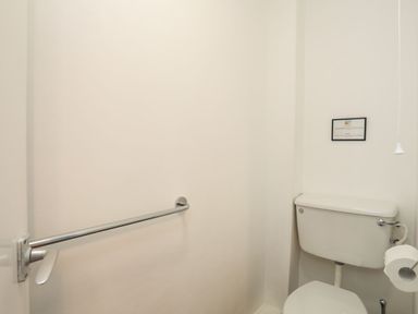 A bathroom with a toilet and grab bar at Penrhyn - 4 Ty'n Don 