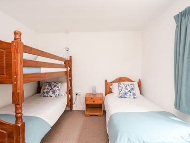 A bedroom with a bunk bed and a single bed at Towyn - 7 Ty'n Don