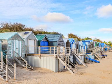A row of beach huts with stairs on a sandy beach at Towyn - 7 Ty'n Don