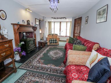 A living room with a fireplace and seating arrangements at The Old Post Office in null