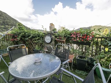 A patio area with a glass table and chairs at The Old Post Office in null