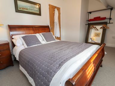 A bedroom with a bed and nightstand at Lenny's Place Watchet