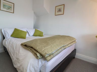 A bedroom with a bed and wall art at Lenny's Place in Watchet