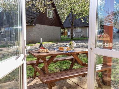 An outdoor dining area with a table set for lunch at Mayfly Lodge, St Tudy