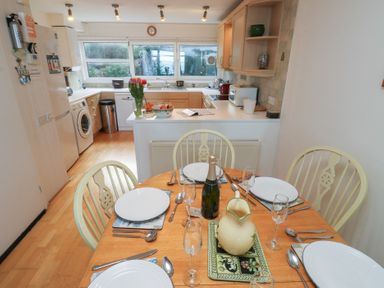 A kitchen with dining table and utensils at 20 Heath Court in Brixham