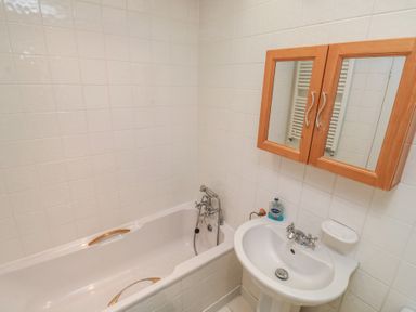 A bathroom with a tub and sink at 20 Heath Court Brixham