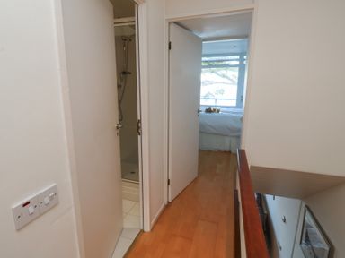 A hallway with doors leading to a shower and bedroom at 20 Heath Court in Brixham