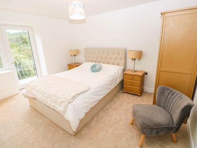 A bedroom with a bed and nightstand at Hawthorns