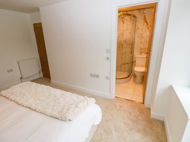 A bedroom with a bed and an adjacent bathroom at Hawthorns