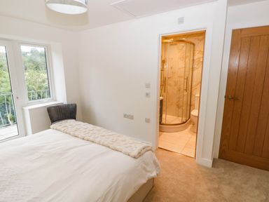 A bedroom with a bed and an en-suite bathroom at Hawthorns