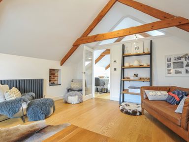 A living room with a sofa and shelving unit at The Dairy in 