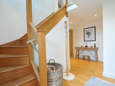 A hallway with a staircase and console table at The Dairy