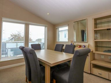 A dining room with a table and chairs at The Hideaway in Pwllheli