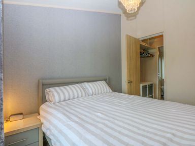 A bedroom with a bed and nightstand at The Hideaway in Pwllheli