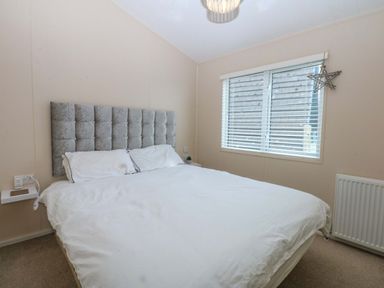 A bedroom with a bed and window at The Hideaway in Pwllheli