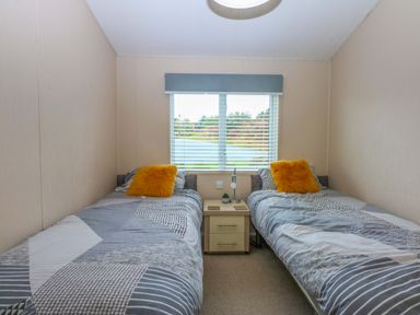 A bedroom with twin beds and a window at The Hideaway in Pwllheli