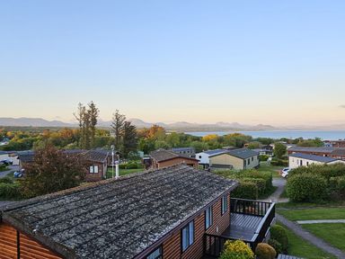 A view of houses and mountains near a lake at The Hideaway Pwllheli