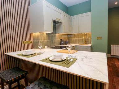 A kitchen with a table and utensils at The Studio in Windermere