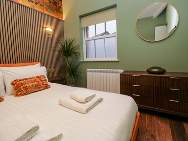 A bedroom with a bed and dresser at The Studio in Windermere