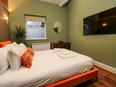 A bedroom with a bed and television at The Studio in Windermere