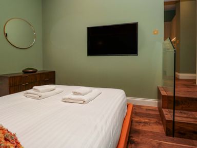 A bedroom with a bed and television at The Studio in Windermere