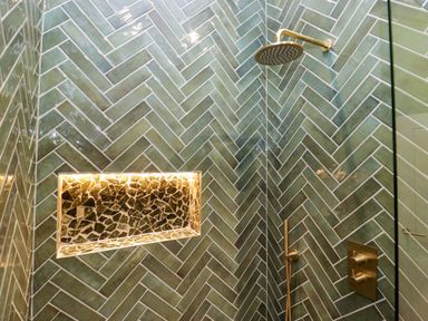 A bathroom with a shower and green tiled walls at The Studio in Windermere