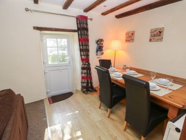 A dining room with a wooden table and chairs at Carthouse Cottage Clarbeston Road