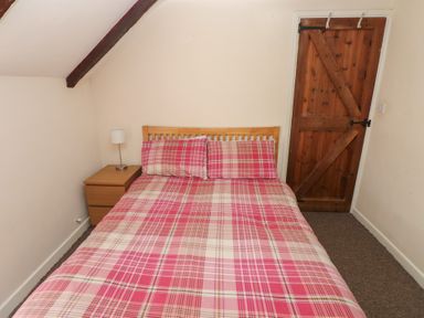 A bedroom with a bed and nightstand at Carthouse Cottage in Clarbeston Road