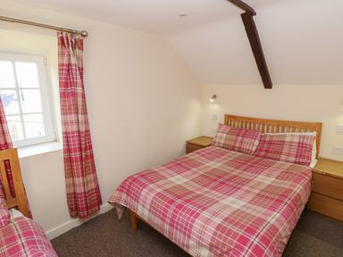 A bedroom with a double bed and a window at Carthouse Cottage in Clarbeston Road